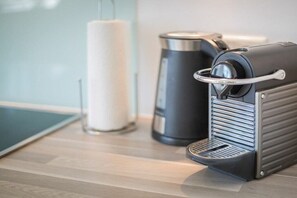 A coffee machine and a cylindrical container on a wooden surface. - Holiday apartment in Sylt with 3 bedrooms (Sylt Westerland)
