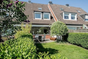 A residential house with a sloped roof, large windows, and a well-maintained garden. - MeerZeit - Süderstraße (Sylt)