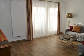 A living room with a sofa, a coffee table, and a lamp. - Holiday apartment with 2 bedrooms (Strullendorf)
