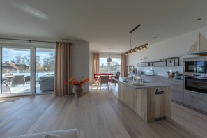 Una cocina moderna con una isla central, ventanas amplias y un comedor con vistas.