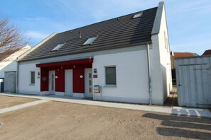 Ein Gebäude mit roter und weißer Fassade, einem geneigten Dach und einem kleinen Fenster.