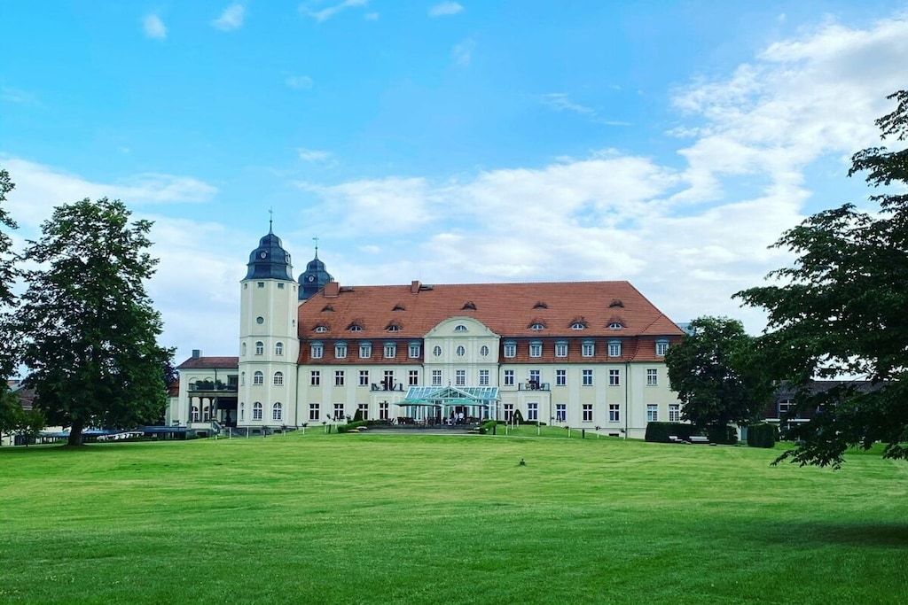 Ein großes, historisches Gebäude mit einem zentralen Turm und einer symmetrischen Fassade.
