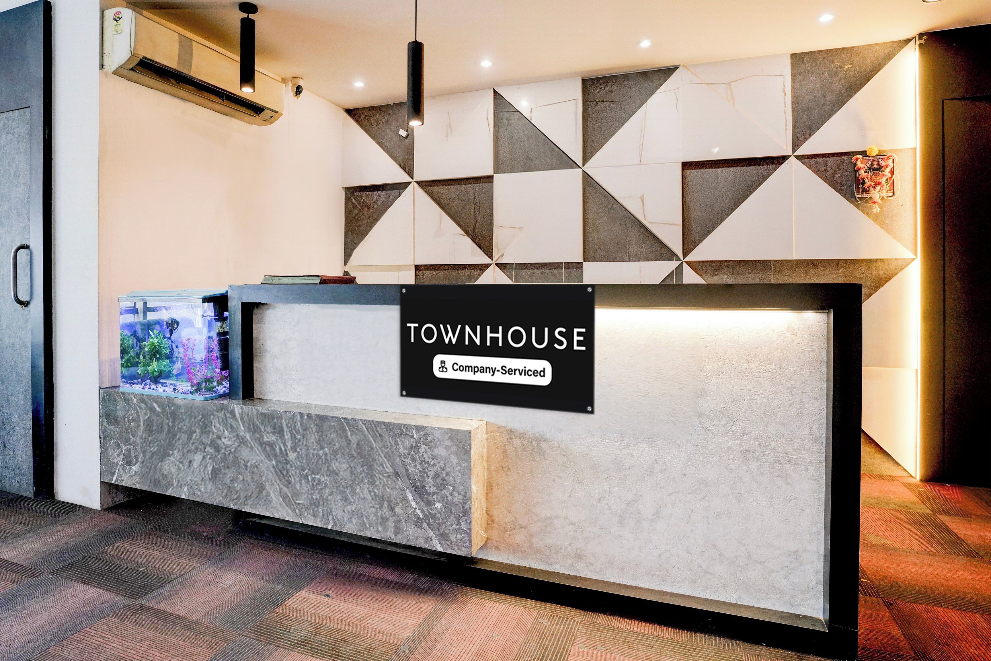 A reception desk with a sign reading 'TOWNHOUSE Company Serviced.'