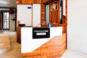 A reception desk with a sign reading 'TOWNHOUSE OAK' and 'Company-Serviced'. - Townhouse Oak Vashi (Navi Mumbai)