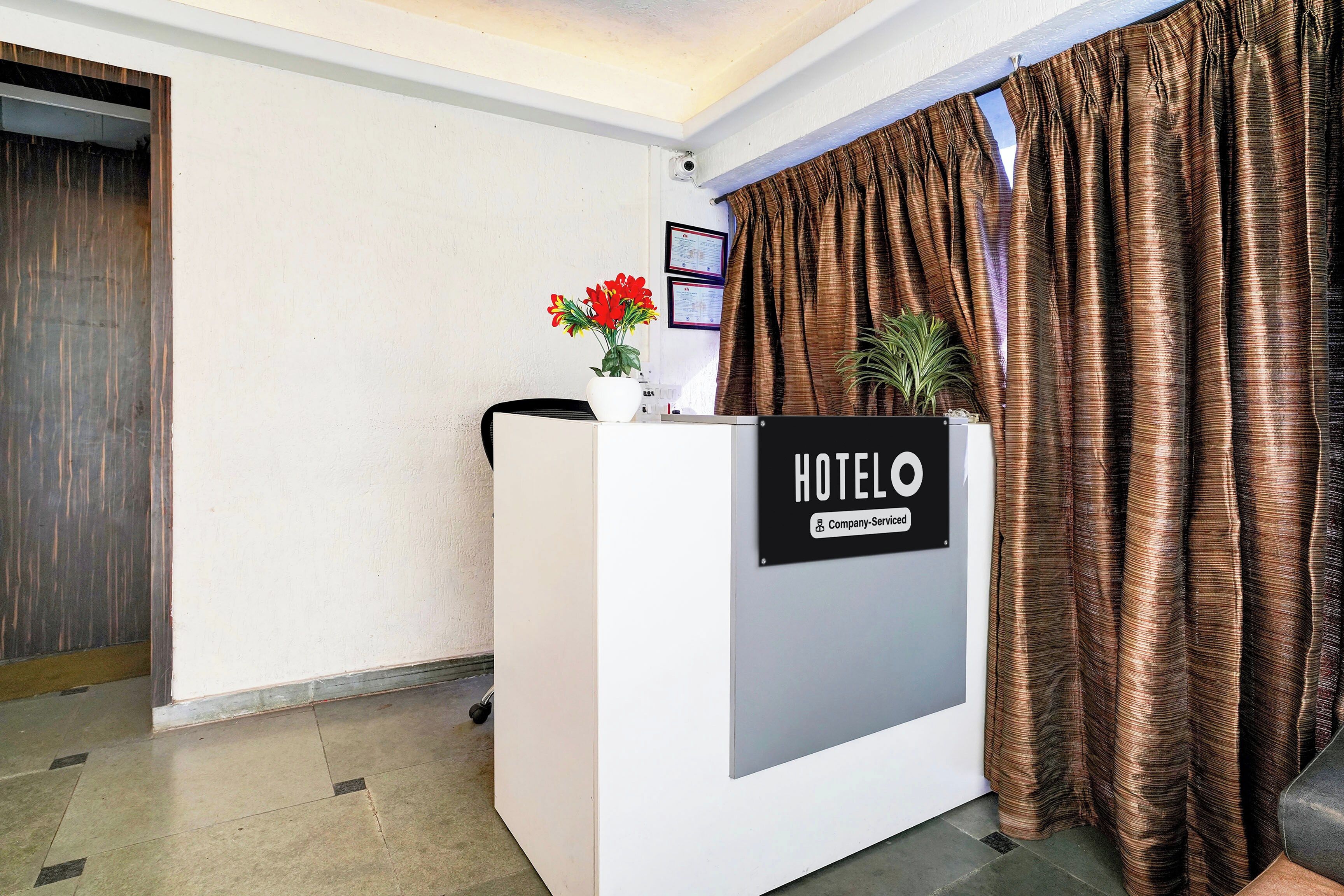 A hotel reception desk with a sign indicating it is company serviced.