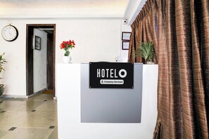 Un mostrador de recepción de hotel con un letrero que indica servicio de empresa.