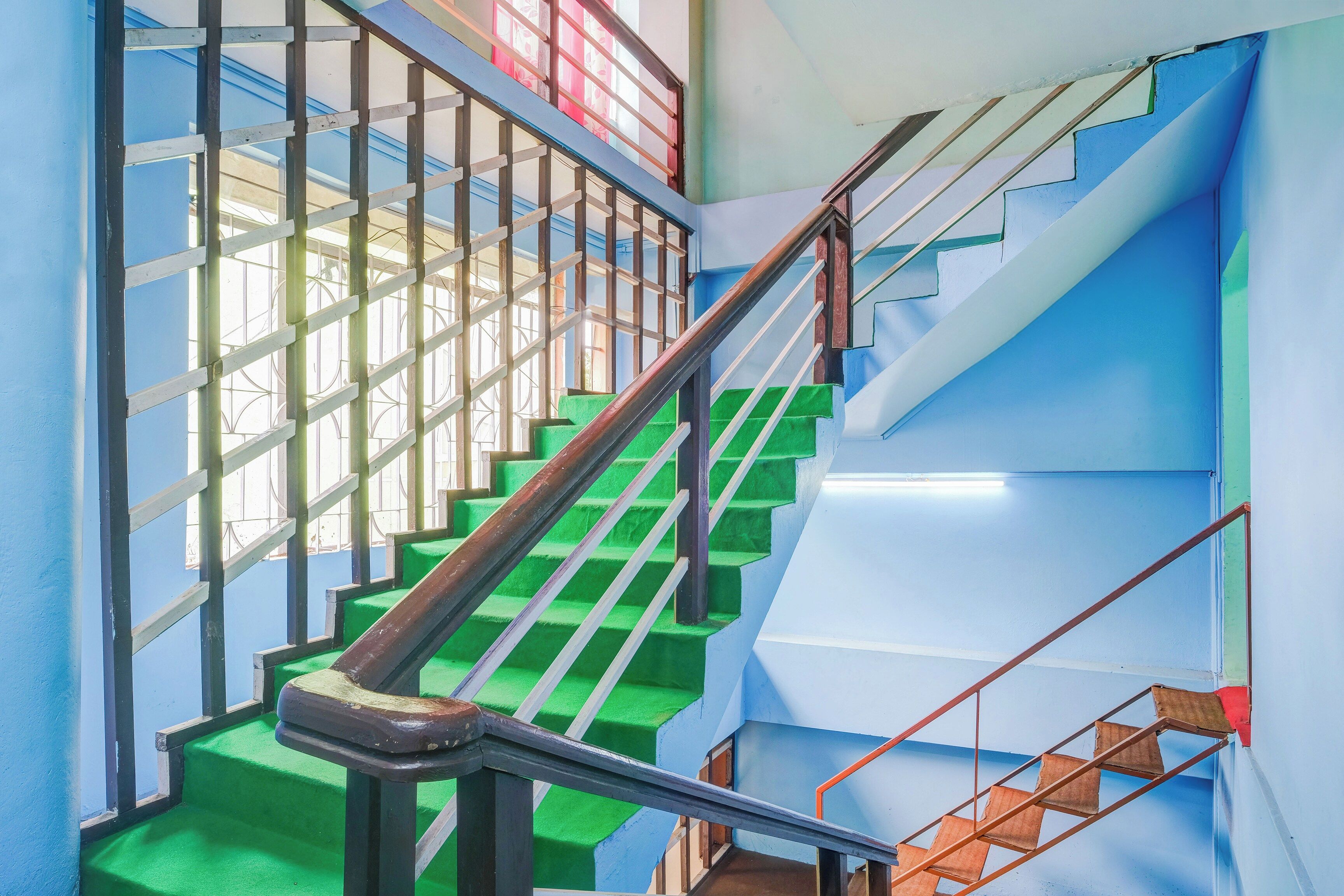 Un escalier avec des marches vertes et des rampes en métal.