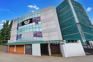 A hotel with a modern facade, a prominent sign, and a series of windows.