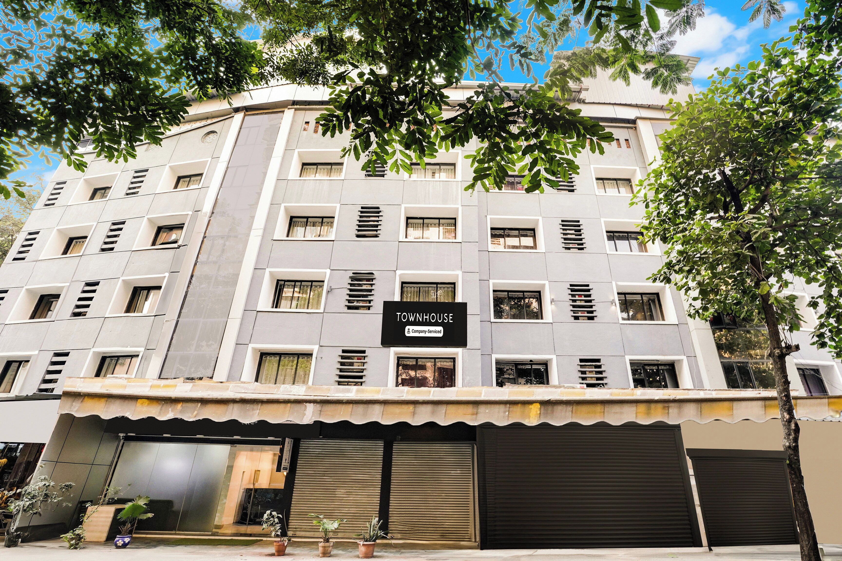 A multi-story building with a sign indicating it is a company-serviced townhouse.