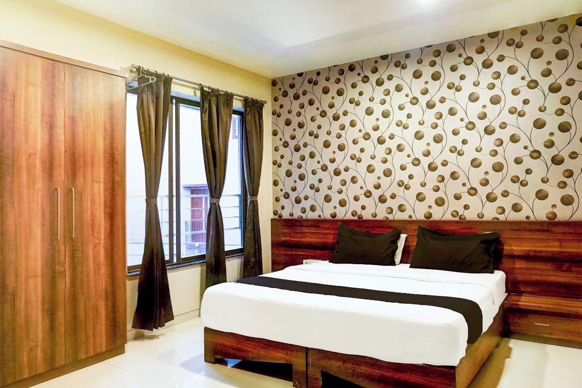 Habitación de hotel con cama, armario de madera y pared con estampado.