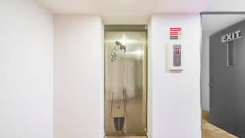 An elevator with a digital display, a fire safety sign, and an exit sign.