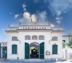 Un edificio con un letrero que dice 'FUNICOLARE' y el año '1898' sobre la entrada.
