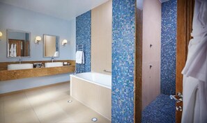 A modern bathroom with a bathtub, two sinks, and a mirror. - South Lodge (Sussex)