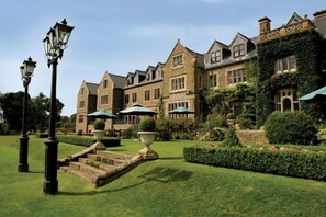 A historic building with a formal garden, stone steps, and outdoor seating areas. - South Lodge (Sussex)