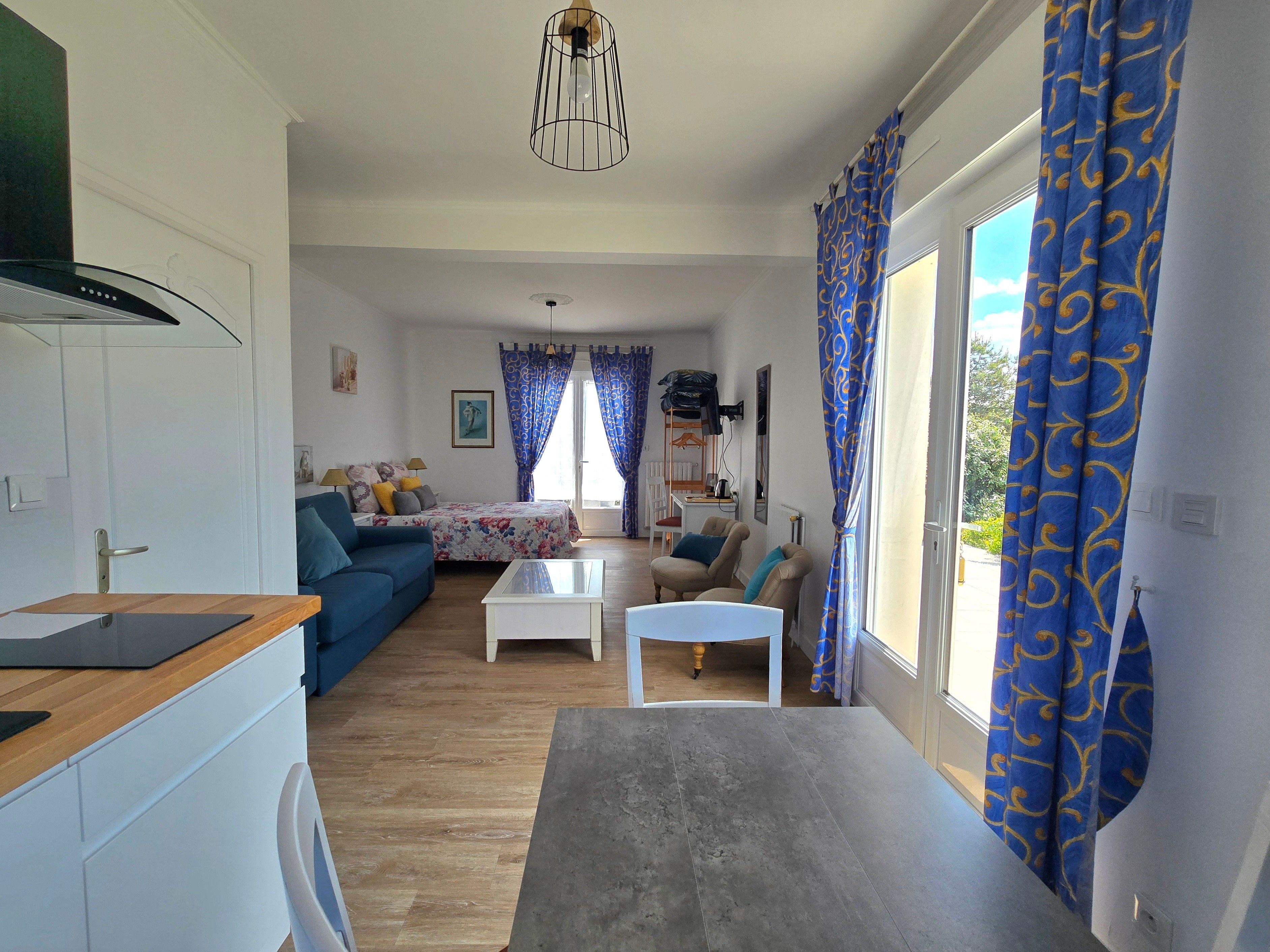 A modern living room with a sofa, coffee table, and a dining area with a table and chairs.
