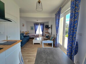 Ein modernes Wohnzimmer mit einer Couch, einem Couchtisch und einem Essbereich mit Tisch und Stühlen.