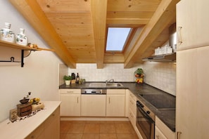 A compact kitchen with a skylight, wooden beams, and a dishwasher. - Alpspitz at the Grasegger holiday home (Garmisch-Partenkirchen)