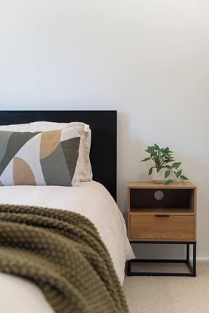 A bedroom with a bed, a bedside table with a plant, and a headboard. - Paddington 3BR Terrace | North-Facing Courtyard (Paddington)