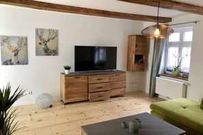 A modern living room with a flat-screen TV, wooden furniture, and artwork on the wall. - Mountain apart 2||Wernigerode (Wernigerode)
