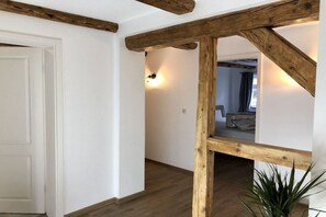 A room with exposed wooden beams, a white door, and a plant. - Mountain apart 5||Wernigerode (Wernigerode)