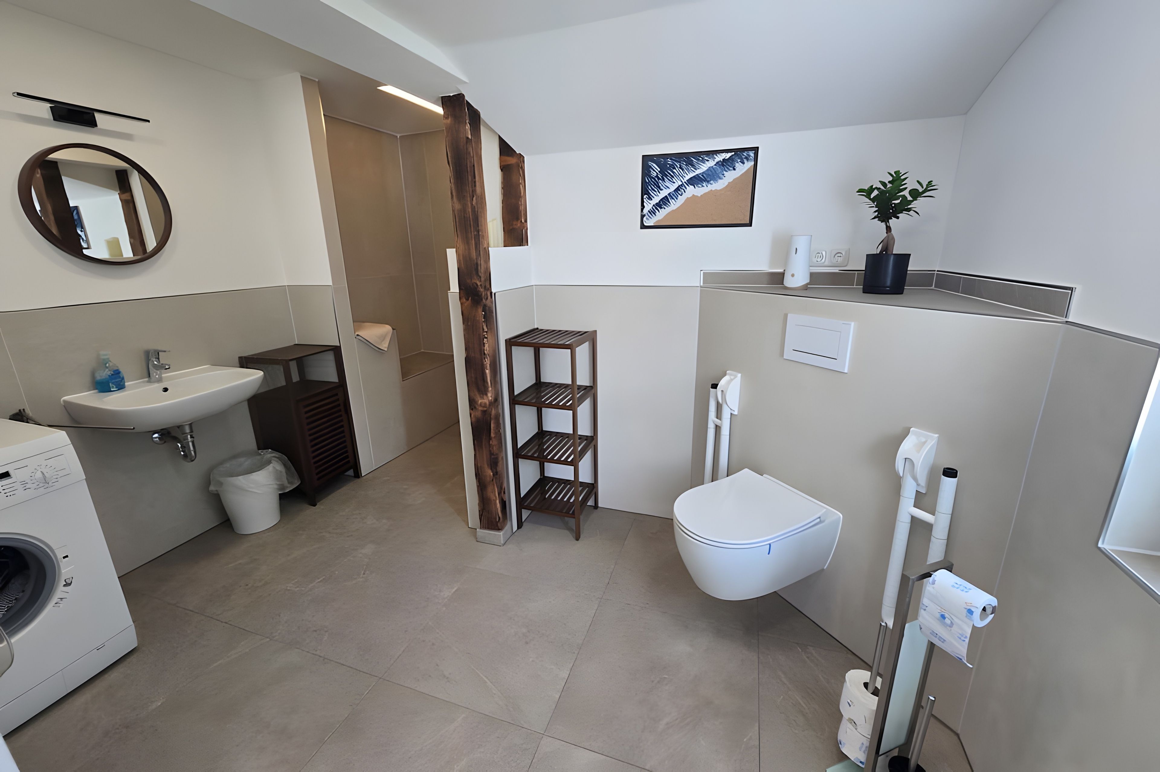 Un bagno moderno con lavatrice, lavandino, WC e uno scaffale in legno.