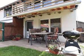 An outdoor patio with a table and chairs, a barbecue grill, and potted plants. - Holiday home with 3 bedrooms (Ilmtal \/ OT Traßdorf)