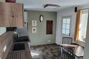 Une cuisine compacte dotée d’une cuisinière intégrée, d’un évier et d’un plan de travail en bois.