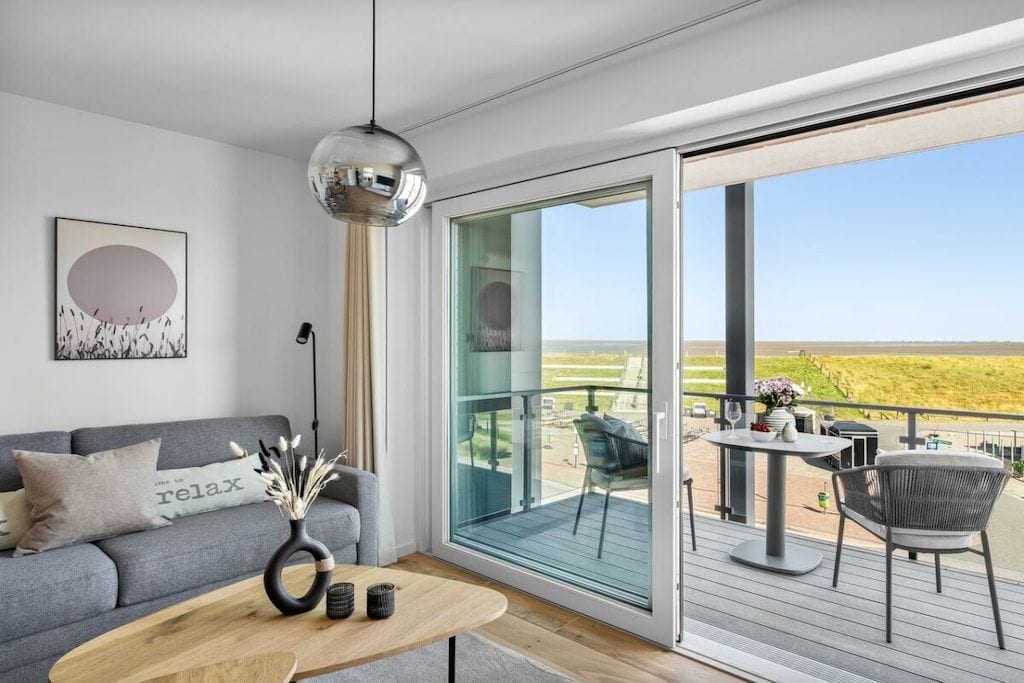 Una sala de estar moderna con un sofá, una mesa de centro y vistas al exterior.