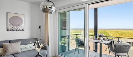Una sala de estar moderna con un sofá, una mesa de centro y vistas al exterior.