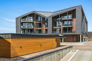 A modern building with a flat roof, large windows, and a wooden facade. - Holiday apartment with 1 bedroom (Dagebüll)