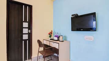 Una habitación con escritorio, silla, televisor y puerta con cerradura de seguridad.