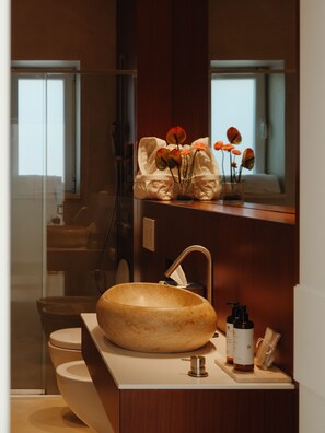 A bathroom with a round sink, a mirror, a towel rack, and a window. - Sea Loft  (Puglia)