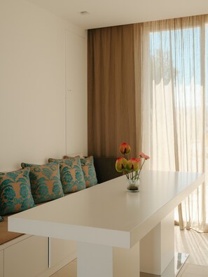 A modern living room with a long white table, a sofa with patterned cushions, and a vase with flowers. - Sea Loft  (Puglia)
