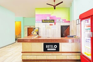 A hotel reception desk with a clock, a reception sign, and a 'No Smoking Area' sign. - Hotel O Gajuwaka Near kurmanpalem (Visakhapatnam)