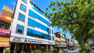 En bygning med flere etager, der har en blå og hvid facade, en tydelig indgang med trapper og et skilt med 'Pagoda Resorts Inn' i stueplan.