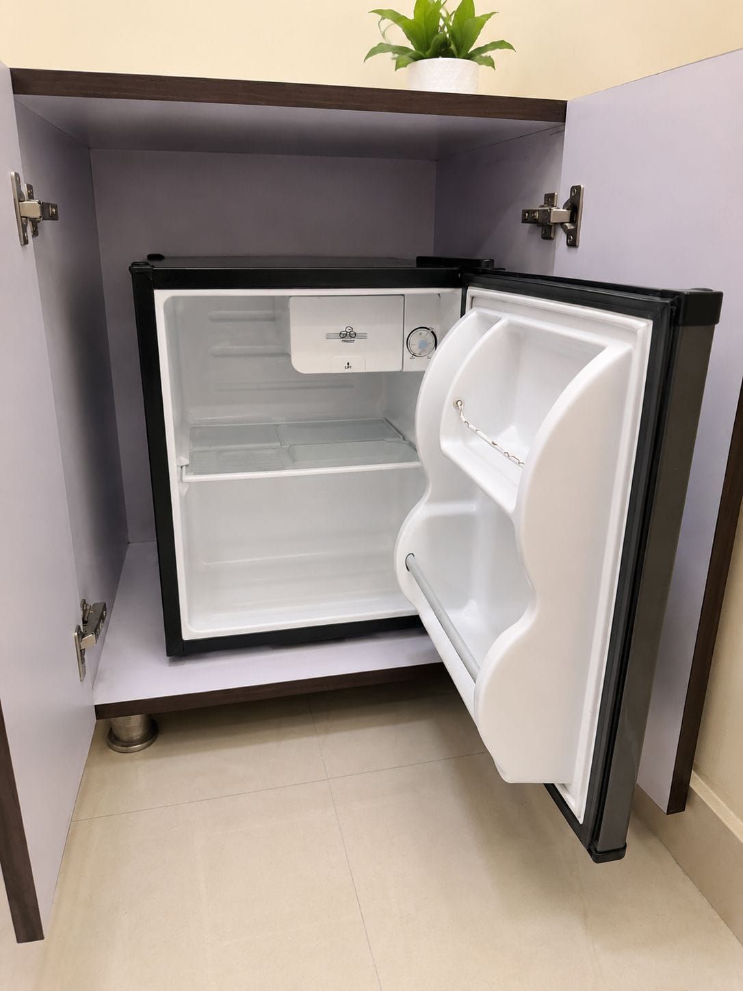 Un refrigerador compacto con compartimento congelador, panel de control y dispensador de agua.