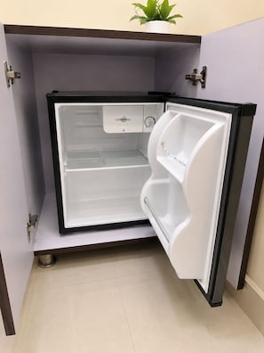 A compact refrigerator with a freezer compartment, a control panel, and a water dispenser. - Pagoda Resorts Inn (Sri Ganganagar)