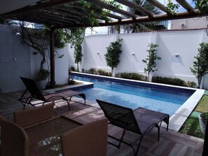 A swimming pool with lounge chairs and a pergola. - New Listing (Natal)