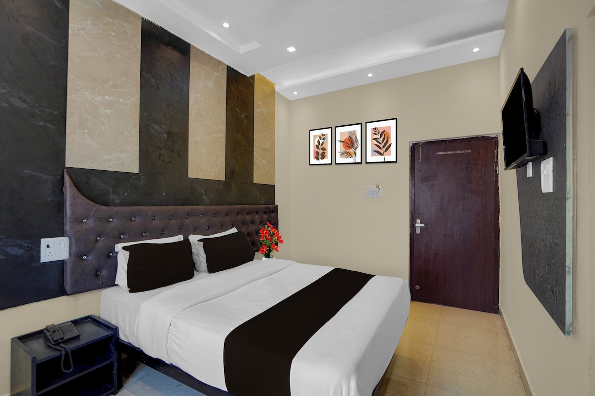 Ein Hotelzimmer mit einem großen Bett, einem Flachbildfernseher und einer Tür.
