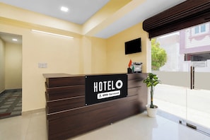 Ein Hotelrezeptionstresen mit einem Schild, auf dem 'HOTEL' und 'Oyo-Serviced' steht.