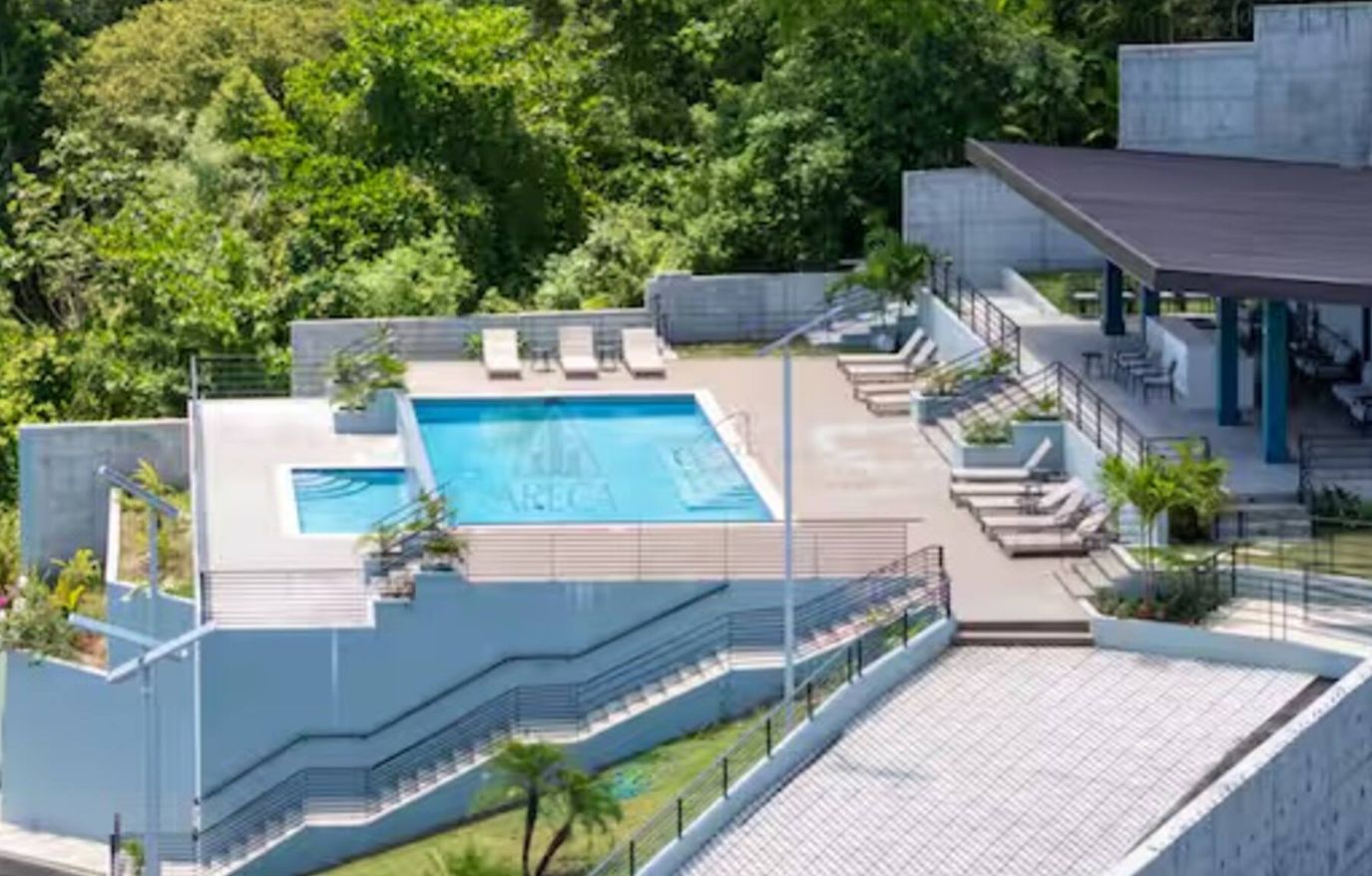 Hotel modern amb piscina al terrat, espais d'estar a l'exterior i zona coberta.