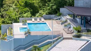 Hotel modern amb piscina al terrat, espais d'estar a l'exterior i zona coberta.
