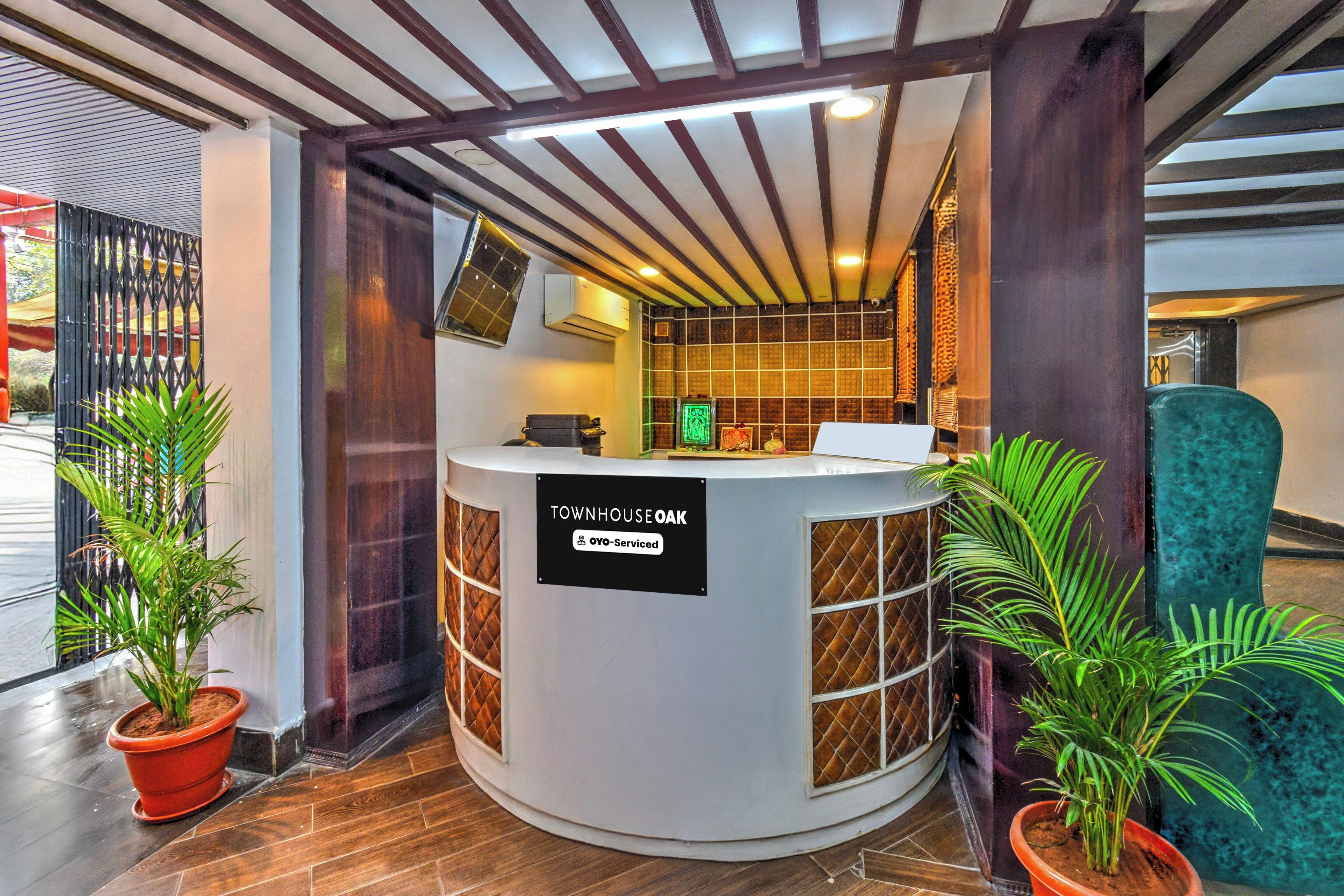 A reception desk labeled 'TOWNHOUSE OAK' with a sign indicating it is serviced by OYO.