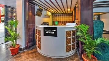 A reception desk labeled 'TOWNHOUSE OAK' with a sign indicating it is serviced by OYO.