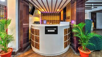 A reception desk with a sign reading 'TOWNHOUSE OAK' and a logo for 'oyo-serviced'.