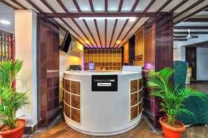 A reception desk with a sign reading 'TOWNHOUSE OAK' and a logo for 'oyo-serviced'. - Townhouse Oak Hotel Banjara Hill (Hyderabad)