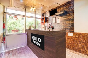 A hotel reception desk with a sign reading 'HOTEL COMPANY-SERVICED'. - Hotel O Clement Town (Dehradun)
