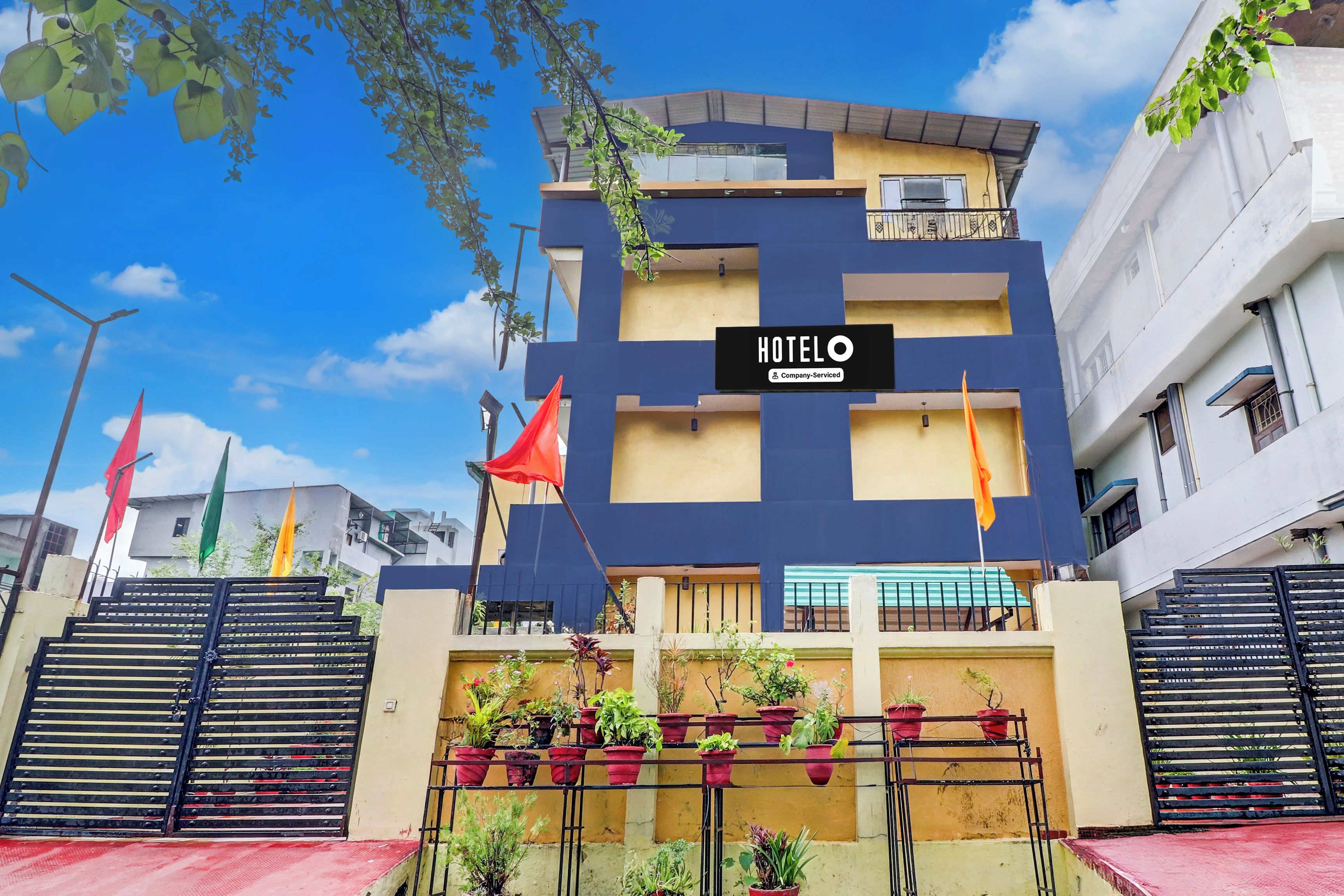 A multi-story building with a sign reading 'HOTEL' and a balcony with potted plants.