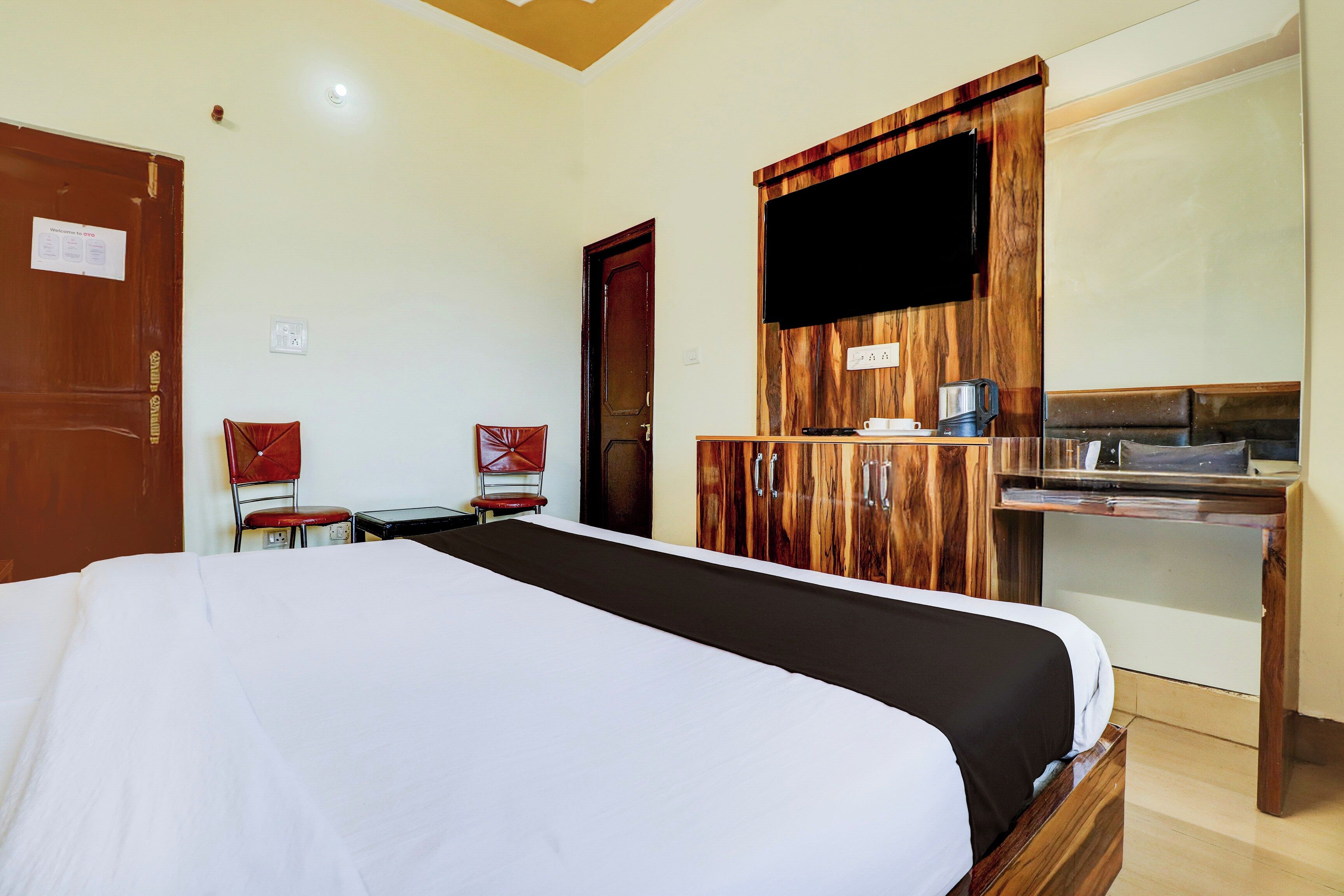 Ein Hotelzimmer mit Bett, Schreibtisch, Kaffeemaschine, Fernseher und Kleiderschrank.