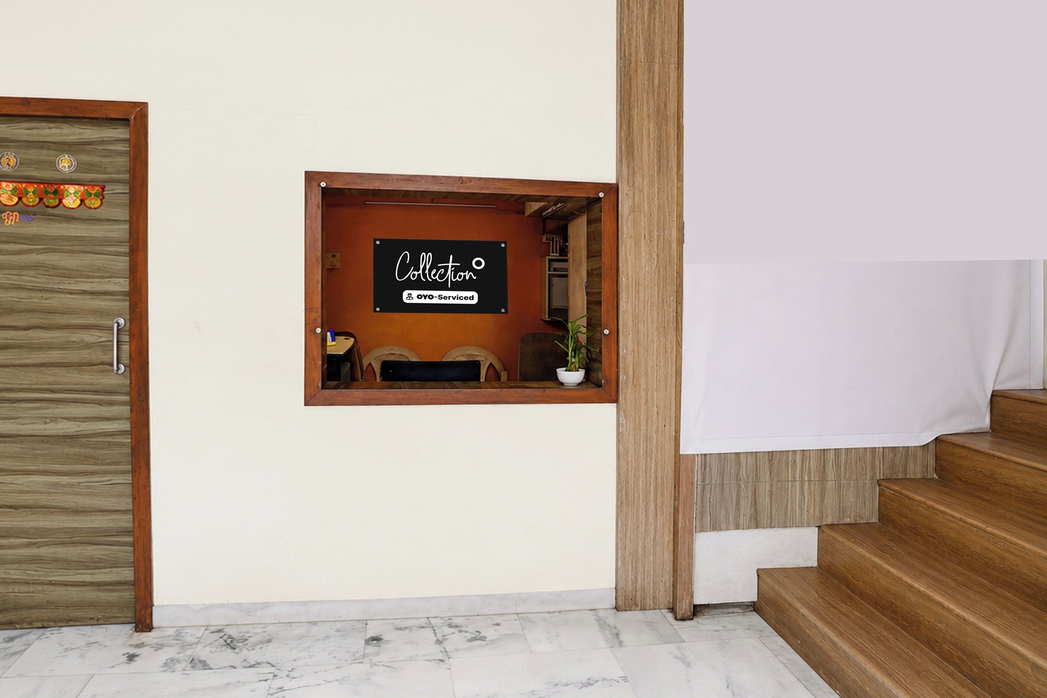 Un área de recepción con un cartel que dice 'Collection' y una pequeña zona de estar con una planta.